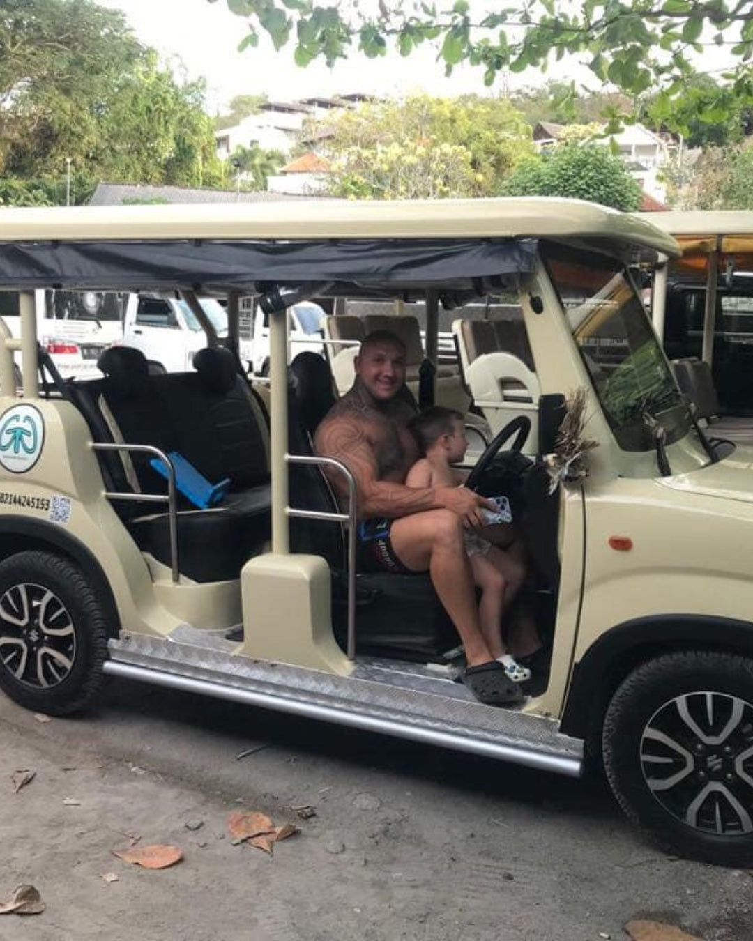 A man sitting behind the wheel of a buggy he has hired on Nusa Lembongan